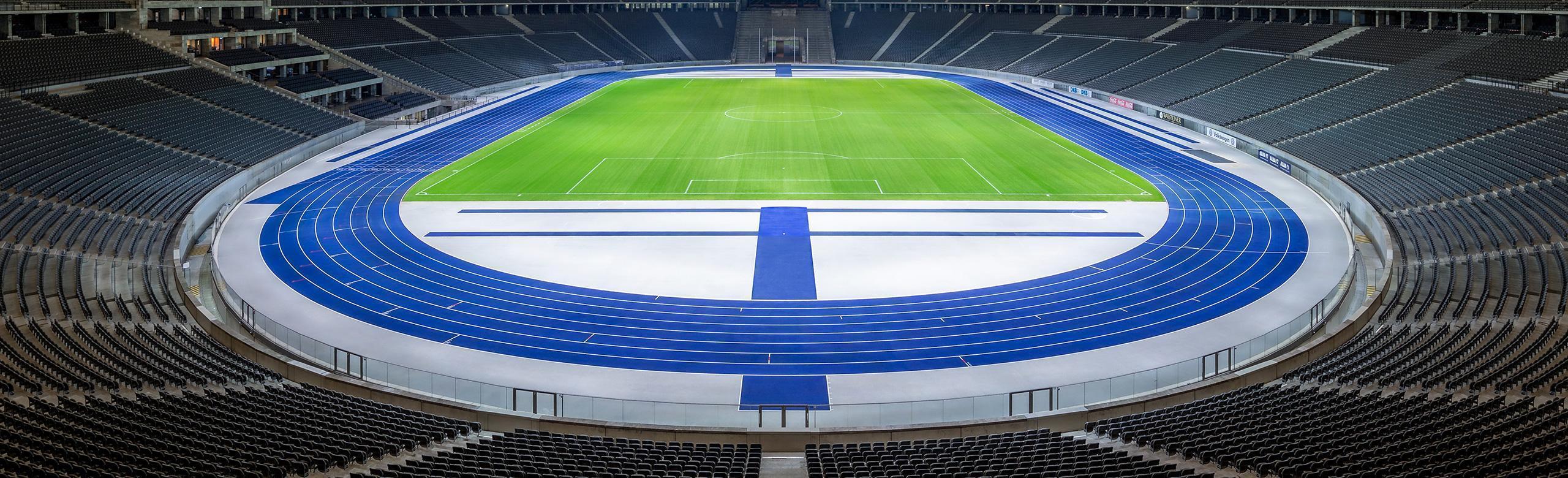 REGUPOL track at Berlin Olympic Stadium – sports surface, athletics, iconic blue View into the empty Olympic Stadium Berlin featuring the distinctive blue REGUPOL running track around the green field. The grandstands are empty